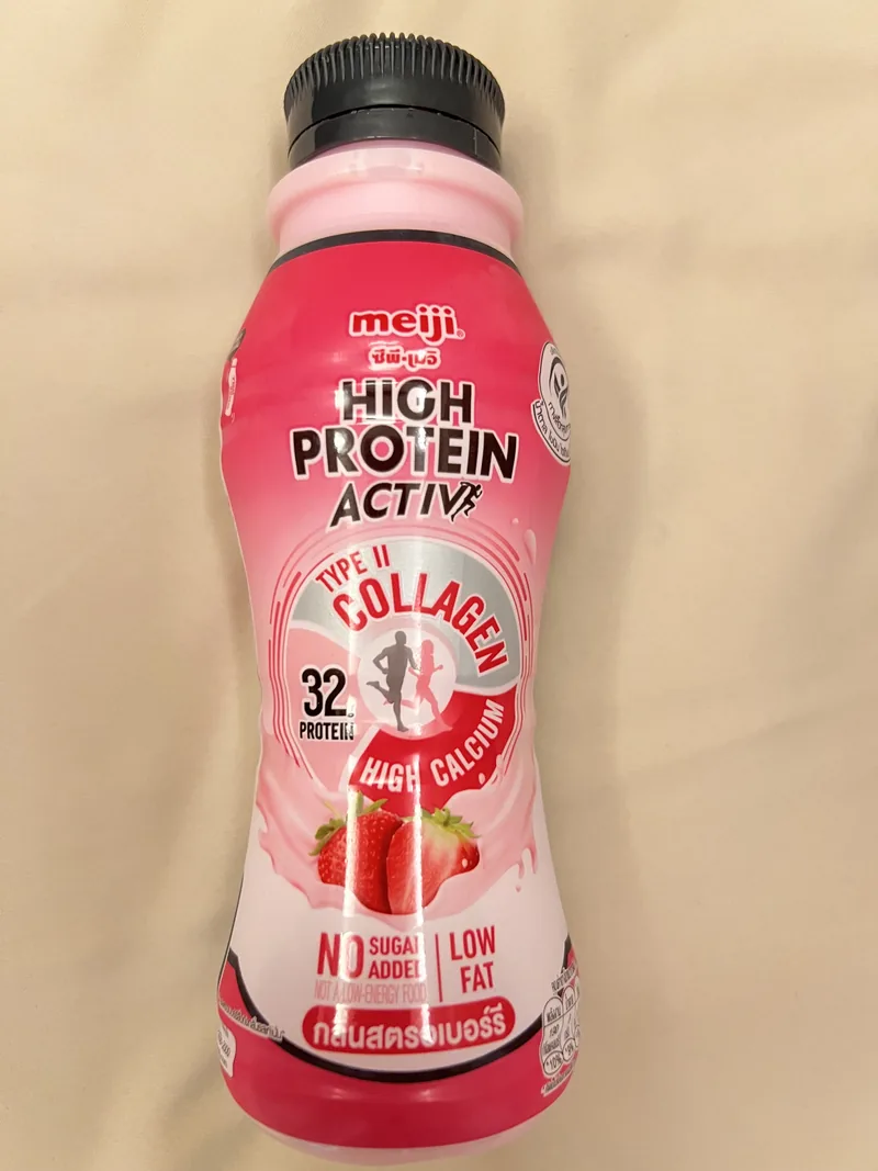 Front of a pink Meiji High Protein Active strawberry bottle declaring 32 grams of protein and Type II collagen